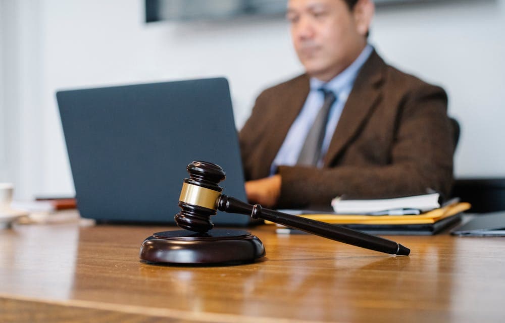 Regulatory agency review — gavel and professional reviewing documents at a desk